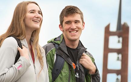 Two students laughing as they chat on campus